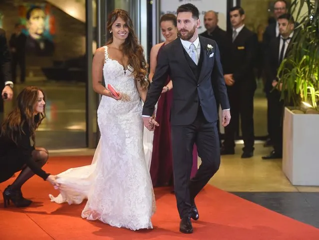 Argentine football star Lionel Messi and bride Antonella Roccuzzo pose for photographers just after their wedding at the City Centre Complex in Rosario, Santa Fe province, Argentina on June 30, 2017. Footballers and celebrities including pop singer Shakira gathered Friday for the “wedding of the century” in Lionel Messi's Argentine hometown as the Barcelona superstar prepared to marry his childhood sweetheart Antonella Roccuzzo. (Photo by Eitan Abramovich/AFP Photo)