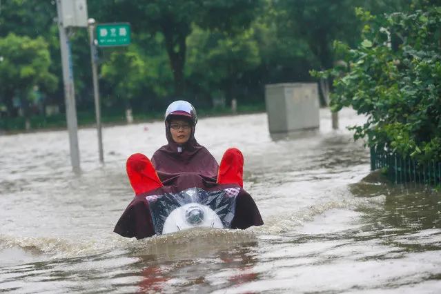 A resident rides a vehicle along a flooded street in Liuzhou, Guangxi Zhuang Autonomous Region, China, June 14, 2016. (Photo by Reuters/Stringer)