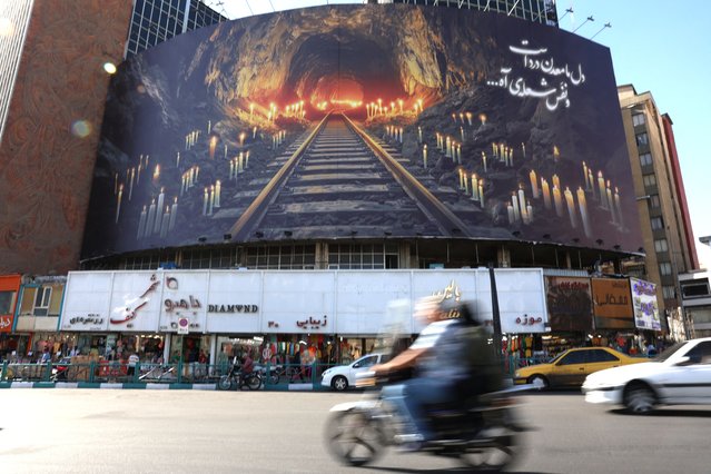 A banner honouring those killed in the blast caused by a gas leak at a coal mine at the Tabas mine in eastern Iran, is erected over a street in the capital Tehran on September 23, 2024. A blast caused by a gas leak at a coal mine has killed at least 51 people, state media said on September 22, in one of Iran's deadliest work accidents in years. (Photo by Atta Kenare/AFP Photo)