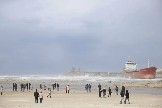 People look at the Zelek Star cargo ship carrying cement stranded in the Mediterranean sea beach in the southern Israeli port city of Ashdod, Friday, December 27, 2019. Strong winds and waves forced the vessel away from its anchor point near the port of Ashdod on Thursday. (Photo by Ariel Schalit/AP Photo)
