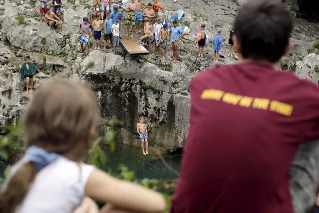 A boy jumps from the cliff during a cliff diving competition in Kanal ob Soci, Slovenia August 16, 2015. (Photo by Srdjan Zivulovic/Reuters)