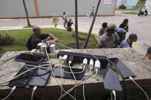 Residents charge their devices after Hurricane Rafael caused partial outages throughout Havana, Cuba Thursday, November 7, 2024. (Photo by Ariel Ley/AP Photo)