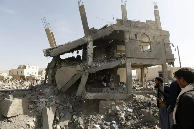 Houthi militants look at the headquarters of the offices of the education ministry's workers union, destroyed by Saudi-led air strikes, in Yemen's northwestern city of Amran August 19, 2015. (Photo by Khaled Abdullah/Reuters)