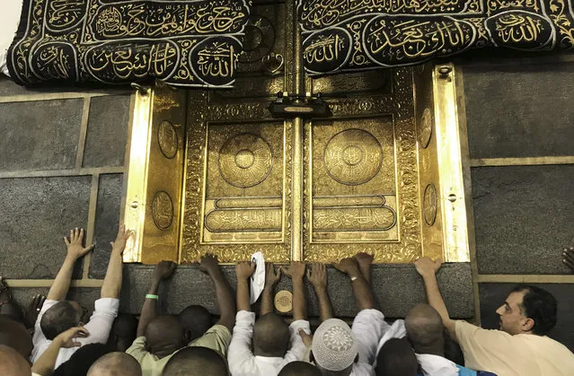 Muslim pilgrims touch the Kaaba stone, the cubic building at the Grand Mosque, ahead of the annual Hajj pilgrimage in the Muslim holy city of Mecca, Saudi Arabia, early Monday, August 28, 2017. (Photo by Khalil Hamra/AP Photo)