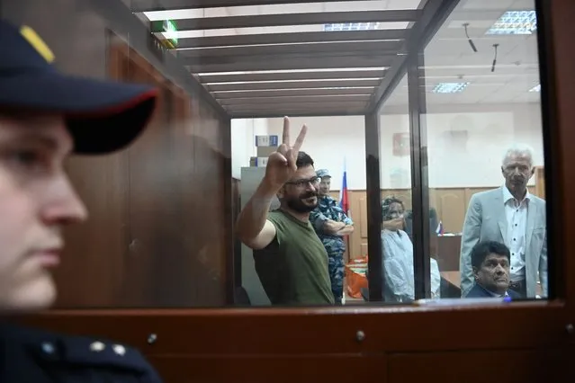 Russian opposition figure and Moscow city councillor Ilya Yashin, charged with “discrediting” the Russian army fighting in Ukraine, flashes the V sign during a hearing on his detention at the Basmanny district court in Moscow on July 13, 2022. (Photo by Kirill Kudryavtsev/AFP Photo)