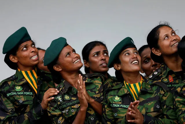 The female Special Task Force members looks up as they watching the sky divers at a demonstration during the 151st Sri Lanka’s Police anniversarya in Colombo, Sri Lanka on September 7, 2017. (Photo by Dinuka Liyanawatte/Reuters)