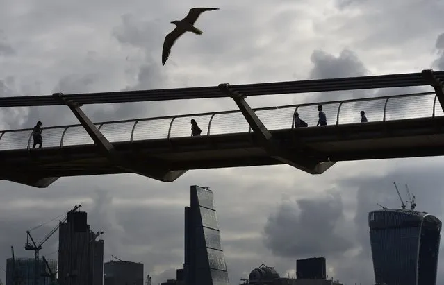 Workers cross the Millenium Bridge with the City of London seen behind, in London July 30, 2014.  Bankers who break the rules may have to hand back bonuses up to seven years after being awarded them, the Bank of England said on Wednesday. (Photo by Toby Melville/Reuters)