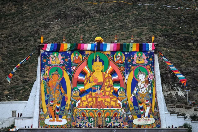 In this Wednesday, July 20, 2016 photo released by Xinhua News Agency, a huge Thangka Buddha portrait is unveiled at the Zhaxi Lhunbo Lamasery during a Buddhist ritual event in Xigaze in southwest China's Tibet Autonomous Region. China's hand-picked Panchen Lama is presiding over a key Buddhist ritual being held in Tibet for only the first time in 50 years, in a move criticized by overseas Tibetan groups. (Photo by Purbu Zhaxi/Xinhua via AP Photo)