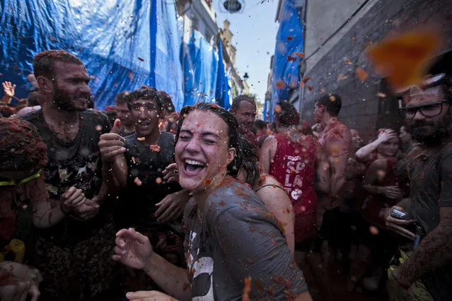Young people take part in the traditional tomato fight “Tomatina” during the week of fiestas in Bunol, Spain, 27 August 2014. Around 22,000 people attended the 69th edition of the traditional tomato throwing festival. (Photo by Gustavo Grillo/EPA)