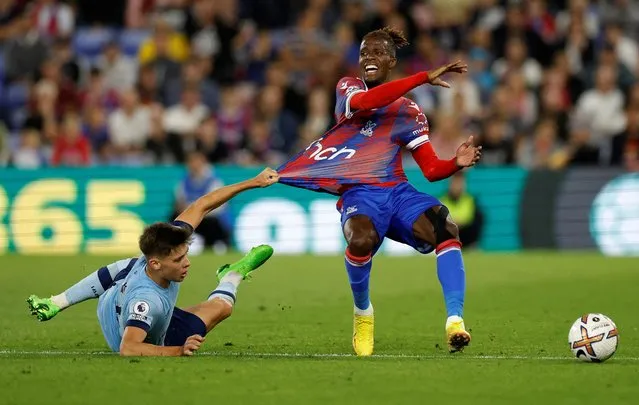 Aaron Hickey of Brentford pulls the shirt and fouls Wilfried Zaha of Crystal Palace during the Premier League match between Crystal Palace and Brentford FC at Selhurst Park on August 30, 2022 in London, United Kingdom. (Photo by Peter Cziborra/Action Images via Reuters)