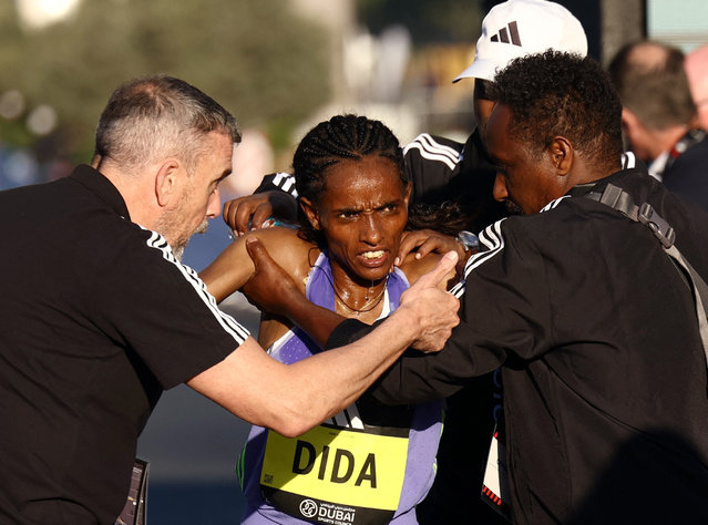 Ethiopia's Dera Dida receives medical attention after finishing second at the Dubai Marathon in United Arab Emirates on January 12, 2025. (Photo by Amr Alfiky/Reuters)