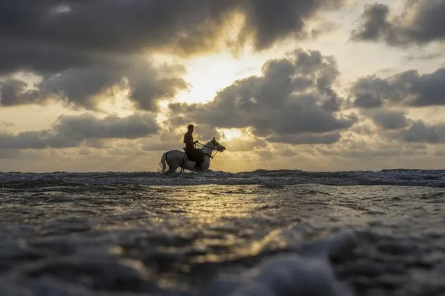 A man rides his horse as the sun sets during a hot day in Mediterranean Sea in Gaza City, Sunday, August 28, 2022. (Photo by Fatima Shbair/AP Photo)