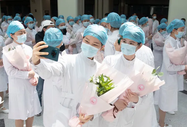 Chinese nurses take a selfie with a mobile phone during a ceremony celebrating International Nurses Day at Tongji Hospital in Wuhan, Hubei province, China, 12 May 2020. International Nurses Day is marked on 12 May, the anniversary of Florence Nightingale's birth, as health workers around the world face unprecedented risks combating the Covid-19 coronavirus outbreak. (Photo by EPA/EFE/China Stringer Network)