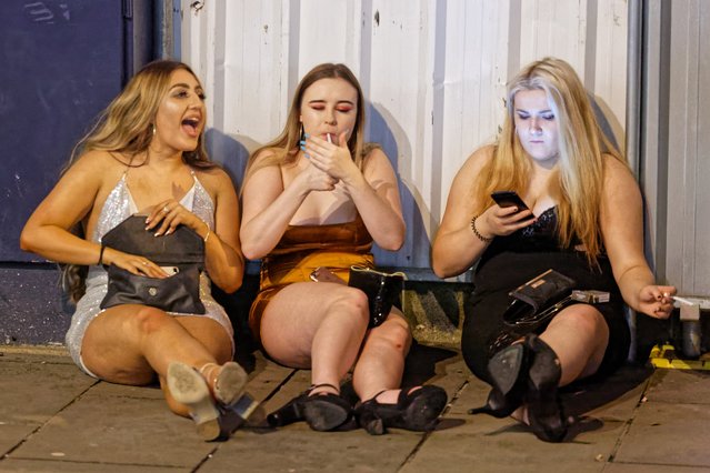 Three female revellers sit on the pavement in Wind Street, Swansea, Wales, UK on Tuesday, 01 January 2019. (Photo by Dimitris Legakis/Athena Picture Agency)