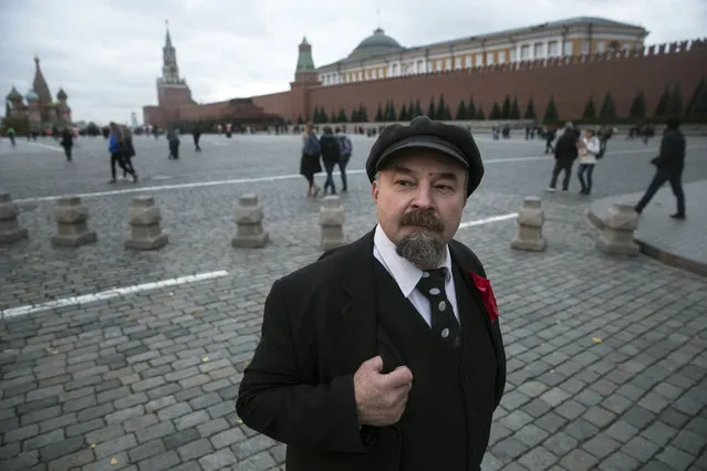 In this photo taken on Wednesday, October 11, 2017, Sergei Soloviev, who impersonates Soviet founder Vladimir Lenin, waits for tourists to pose for photos in Red Square in Moscow, Russia. Visitors are forbidden to photograph Vladimir Lenin’s mummified body in the mausoleum on Red Square – but nearby, Sergei Soloviev is happy to offer an alternative. (Photo by Pavel Golovkin/AP Photo)