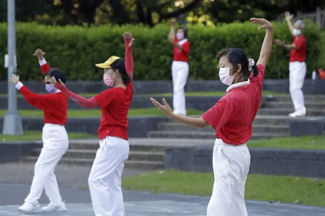 People wearing face masks to protect against the spread of the coronavirus take morning exercises at a park in Taipei, Taiwan, Wednesday, September 28, 2022. (Photo by Chiang Ying-ying/AP Photo)