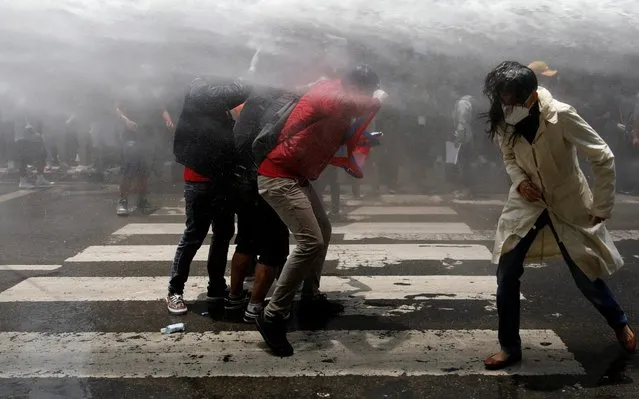 Nepalese youths brave the water cannon during a protest near the Prime Minister's official residence, demanding better and effective response from the government to fight the coronavirus disease (COVID-19) outbreak as the number of infections spikes, in Kathmandu, Nepal on June 11, 2020. (Photo by Navesh Chitrakar/Reuters)