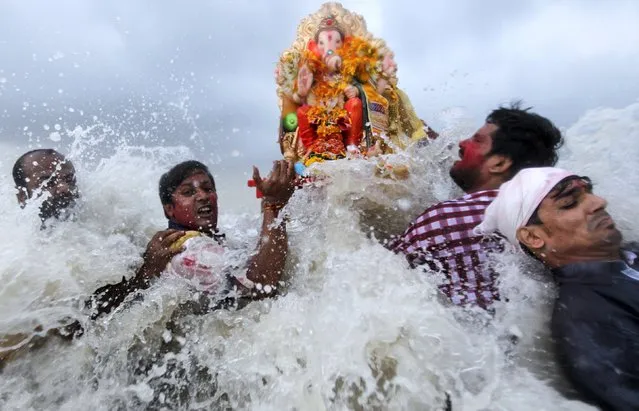 Devotees carry an idol of the Hindu god Ganesh, the deity of prosperity, into the Arabian Sea on the fifth day of the ten-day-long Ganesh Chaturthi festival in Mumbai, India, September 21, 2015. (Photo by Danish Siddiqui/Reuters)