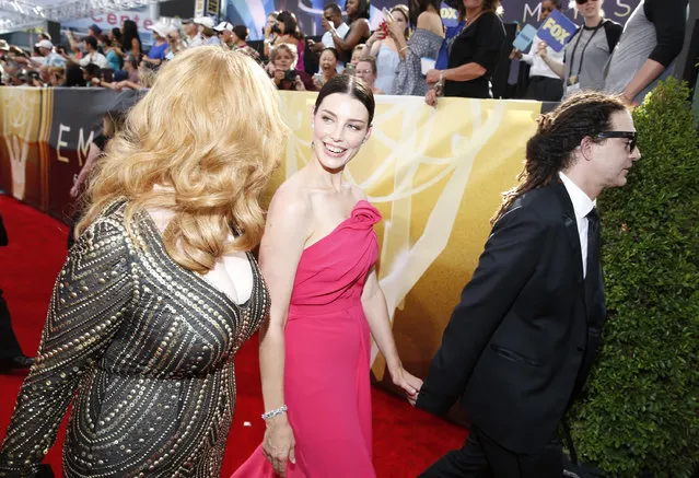 Christina Hendricks, left, and Morena Baccarin arrive at the 67th Primetime Emmy Awards on Sunday, September 20, 2015, at the Microsoft Theater in Los Angeles. (Photo by Eric Jamison/Invision for the Television Academy/AP Images)