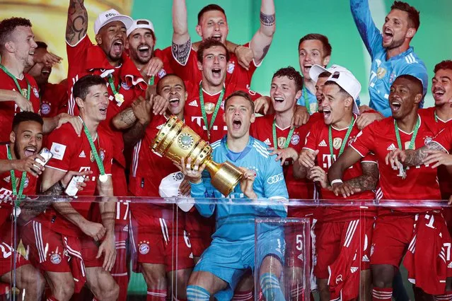 Bayern Munich's Manuel Neuer celebrates with the trophy and teammates after winning the DFB Cup, in Berlin, Germany on July 4, 2020. (Photo by Michael Sohn/Pool via Reuters)