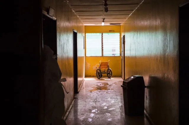 A empty wheelchair marks the scene inside a hallway near Ebola patients at the Redemption  Hospital which has become a transfer and holding center to intake Ebola patients located in one of the poorest neighborhoods of Monrovia that locals call “New Kru Town” on Saturday September 20, 2014 in Monrovia, Liberia. (Photo by Michel du Cille/The Washington Post)