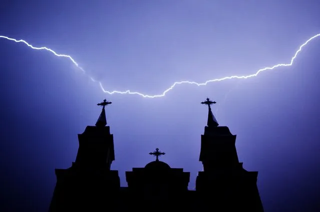 Lightning strikes are seen above a Catholic church during a thunderstorm in the village of Kreva, some 100 km northwest of Minsk, late on June 9, 2020. (Photo by Sergei Gapon/AFP Photo)