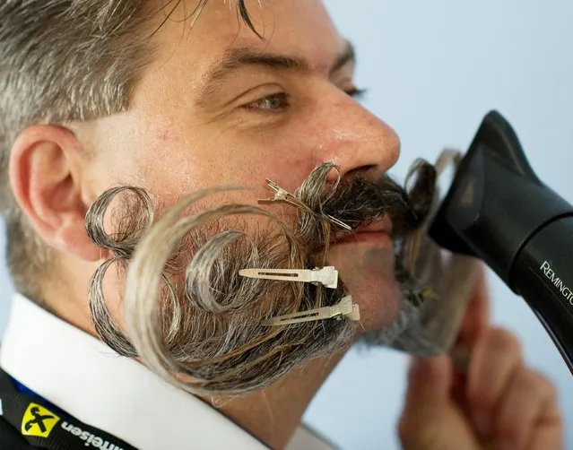 A participant blow dries his moustache at the 2015 World Beard and Moustache Championships in Leogang, Austria, 03 October 2015. More than 350 men from 20 nations are competing in 18 categories. (Photo by Angelika Warmuth/EPA)