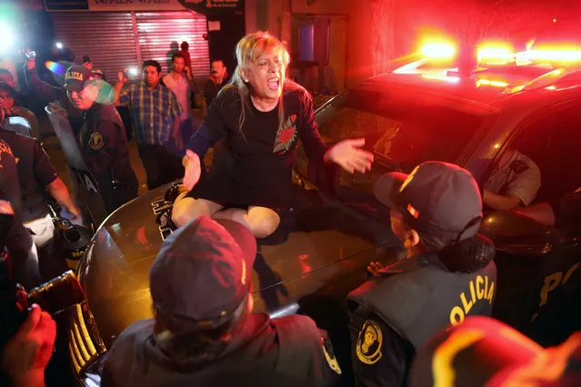 A woman who is opposed the pardoning of former Peruvian president Alberto Fujimori (1990-2000), protest on a police patrol vehicle in Lima, Peru, 04 January 2018. Fujimori left the Centenario de Lima clinic on 04 January, in which he was hospitalized for 12 days and after having been pardoned by President Pedro Pablo Kuczynski. (Photo by Ernesto Arias/EPA/EFE)