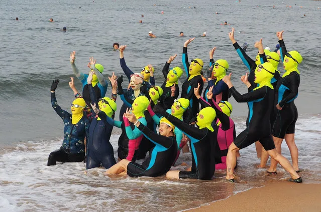 A team of female swimmers wearing facekini pose on beach by the sea on August 18, 2020 in Qingdao, Shandong Province of China. (Photo by Qian Han/VCG via Getty Images)