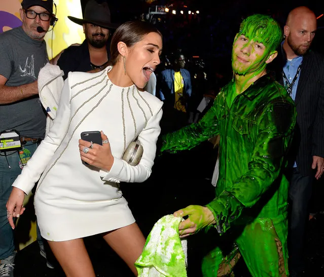 Model Olivia Culpo (L) and host Nick Jonas, after getting slimed, backstage during Nickelodeon's 28th Annual Kids' Choice Awards held at The Forum on March 28, 2015 in Inglewood, California. (Photo by Lester Cohen/KCA2015/WireImage)