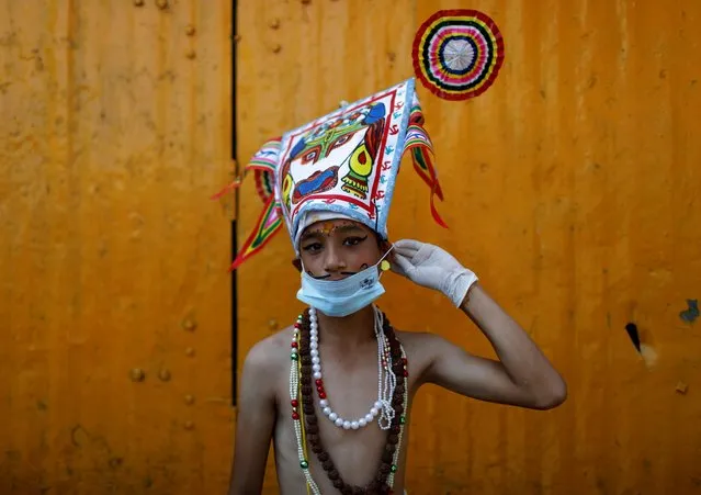 A boy dressed as a holy cow wears a facemask as he participates in a parade to mark Gaijatra Festival, also known as the festival of cows, amid the coronavirus pandemic in Kathmandu, Nepal on August 4, 2020. Hindus in Nepal celebrate the festival to ask for salvation and peace for their departed loved ones. Cows are regarded as holy animals in Nepal that help departed souls reach heaven. (Photo by Navesh Chitrakar/Reuters)
