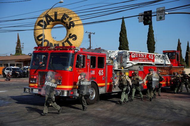 Members of security forces walk next to a firetruck amidst a standoff between police and protesters following multiple detentions by ICE, in the Los Angeles County city of Compton, California, U.S., June 7, 2025. (Photo by Daniel Cole/Reuters)