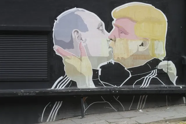 A view of a graffiti mural by Lithuanian artist Mindaugas Bonanu depicting US Republican presidential candidate Donald Trump (R) kissing Russian President Vladimir Putin on the wall of a barbacue restaurant Keule Ruke in Vilnius, Lithuania, 04 August 2016. (Photo by Valda Kalnina/EPA)