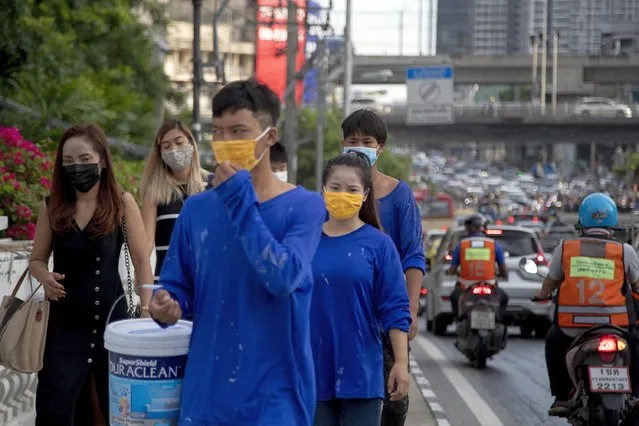 Office workers and construction workers with face masks walk in a side walk in Bangkok, Thailand, Thursday, September 3, 2020. Thailand's prime minister on Wednesday congratulated his countrymen on the nation having achieved 100 days without a new confirmed locally transmitted case of the coronavirus, even as security along the border with Myanmar is being stepped up as a measure against the disease. (Photo by Gemunu Amarasinghe/AP Photo)