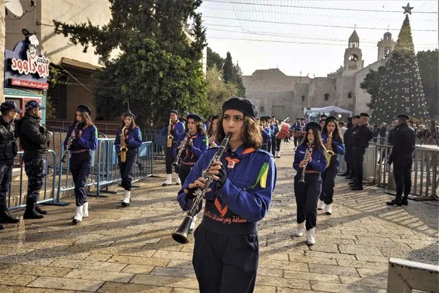Girls scouts march during Christmas parade in Manger Square, adjacent to the Church of the Nativity, traditionally believed to be the birthplace of Jesus Christ, in the West Bank town of Bethlehem, Saturday, December 24, 2022. (Photo by Maya Alleruzzo/AP Photo)