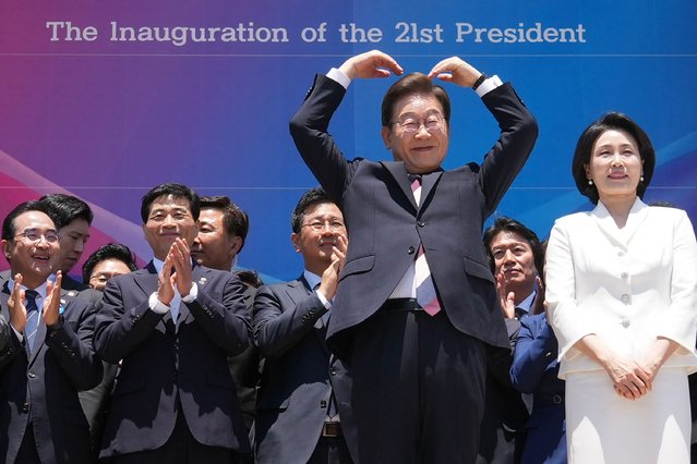 South Korea's President Lee Jae-myung (2nd R) makes an arm heart gesture to the people outside the National Assembly as he and his wife Kim Hye-kyung (R) leave following the inauguration ceremony in Seoul on June 4, 2025. (Photo by Lee Jin-man/Pool via AFP Photo)