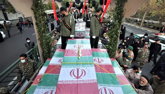 Mourners attend a funeral procession carrying the remains of 200 Iranian soldiers recovered from former battlefields of the Iran-Iraq war (1980-1988), in Tehran on December 27, 2022. (Photo by AFP Photo/Stringer)