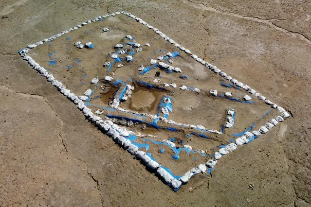 An aerial picture shows a general view of the newly-excavated trench which may have contained an inn with a cooling area for food storage, at the site of the ancient city-state of Lagash, in Iraq's al-Shatra district of the southern Dhi Qar province on February 11, 2023. Italian and US archaeologists excavating in Lagash in southern Iraq have unearthed a Sumerian “tavern” old nearly 5,000 years old, complete with benches, a cooling system acting as a refrigerator, and bowls containing leftover food. (Photo by Asaad Niazi/AFP Photo)