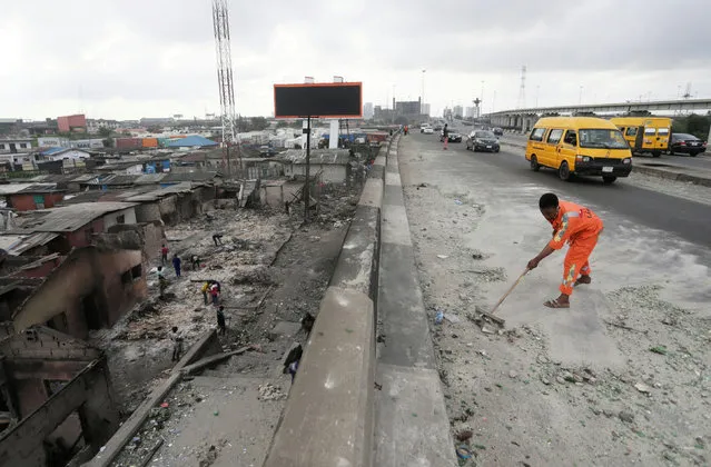 A worker cleans a street, as Nigeria's Lagos state eases a round-the-clock curfew imposed in response to protests against alleged police brutality, after days of unrest, in Lagos, Nigeria on October 24, 2020. (Photo by Afolabi Sotunde/Reuters)