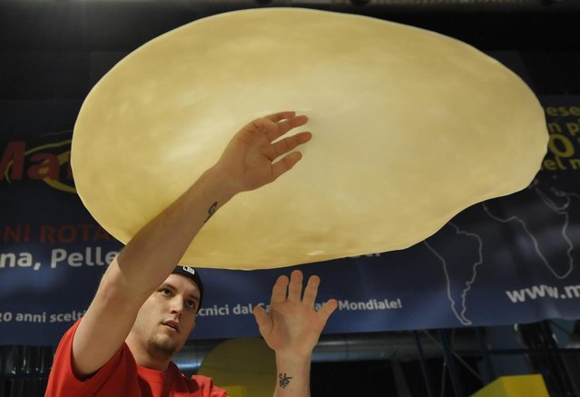 Bradley Johnson, of United States, performs with his dough during the freestyle event, part of the Pizza World Championships, in Parma, northern Italy, Wednesday, April 17, 2013. The 22th edition of the championships run from April 15 to April 17. (Photo by Marco Vasini/AP Photo)