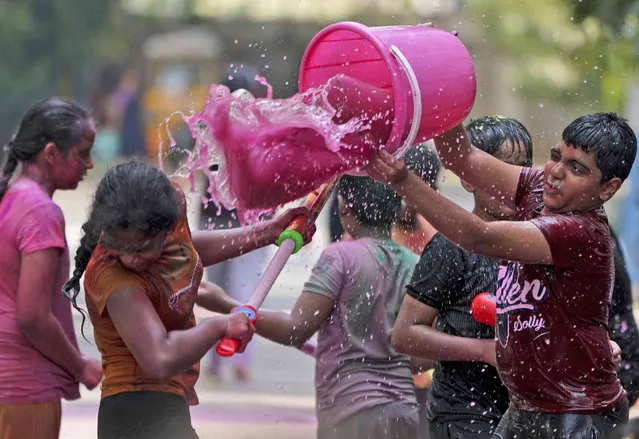 Children play with color water as they celebrate Holi, the Hindu festival of colors, in Hyderabad, India, Tuesday, March 7, 2023. (Photo by Mahesh Kumar A./AP Photo)