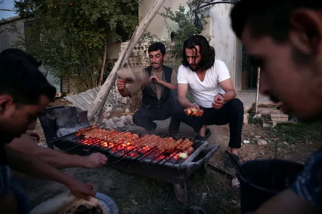 Crew of a film directed by Humam Husari grill meat after the end of filming in the rebel held Douma neighbourhood of Damascus, Syria October 6, 2016. (Photo by Bassam Khabieh/Reuters)