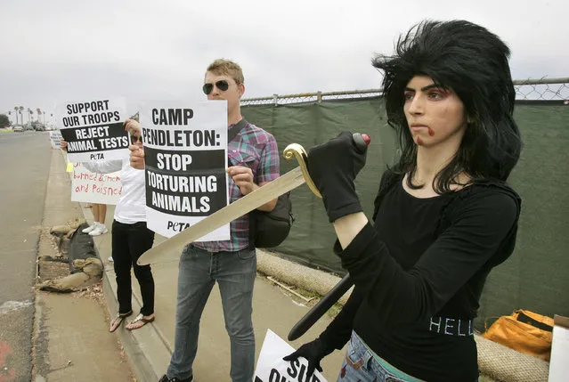 This August 12, 2009, photo shows Nasim Aghdam, right, as she joins members of People for the Ethical for Animals, PETA, protesting at the main gate of Marine Corps base Camp Pendleton in Oceanside, Calif., against the Marine's killings of pigs in a military exercise. Law enforcement officials have identified Nasim Aghdam as the person who opened fire with a handgun Tuesday, April 3, 2018, at YouTube headquarters in San Bruno, Calif., wounding several people before fatally shooting herself. (Photo by Charlie Neuman/The San Diego Union-Tribune via AP Photo)