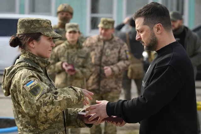 Ukrainian President Volodymyr Zelenskyy presents a medal to a servicewoman in Okhtyrka in the Sumy region of Ukraine, Tuesday March 28, 2023. A team of journalists from The Associated Press traveled with Zelenskyy aboard his train for two nights as he visited troops along the front lines and communities that have been liberated from Russian control. Zelenskyy is hoping his trips keep the public's attention on the war, particularly in parts of Ukraine where life can often appear to have returned to normal. (Photo by Efrem Lukatsky/AP Photo)