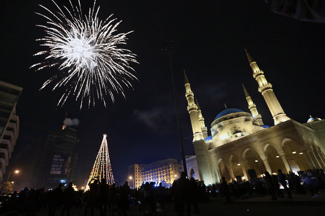 Lebanese watch a firework display during the New Year's celebrations at midnight in downtown Beirut, Lebanon, Thursday, January 1, 2015. (Photo by Bilal Hussein/AP Photo)