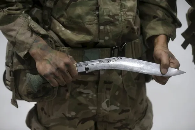 British army gurkha of UK-based NATO Allied Rapid Reaction Corps (ARRC) shows traditional Nepalese knife khukuri during military exercise Arrcade Fusion 2015 in Lielvarde, Latvia, November 17, 2015. (Photo by Ints Kalnins/Reuters)