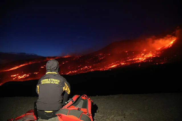 Member of the Guardia di Finanza alpine rescue looks on as Mount Etna, Europe's highest and most active volcano, erupts in Sicily, Italy, July 27, 2019. (Photo by Antonio Parrinello/Reuters)