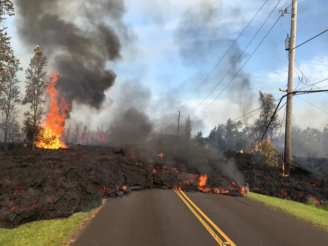 Lava advances along a street near a fissure in Leilani Estates, on Kilauea Volcano's lower East Rift Zone, Hawaii on May 6, 2018. (Photo by Reuters/U.S. Geological Survey)