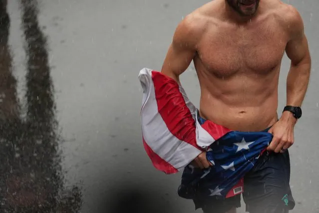 A flag of the U.S. is held by a participant at the end of the 127th Boston Marathon in Boston, Massachusetts, U.S. on April 17, 2023. (Photo by Sophie Park/Reuters)
