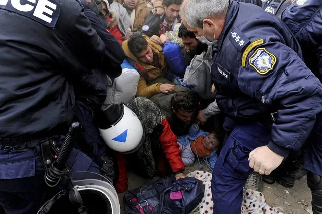A child (bottom)  falls on the ground as Greek policemen pushed back Syrian, Iraqi and Afghan refugees who tried to force their way through the Greek-Macedonian borders near the village of Idomeni, Greece November 22, 2015. (Photo by Alexandros Avramidis/Reuters)